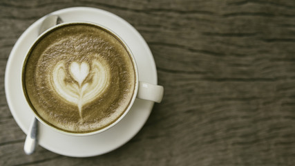 Coffee cup with latte art on the wood table. vintage effect style picture