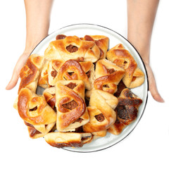 Buns with raisins in a hand on a white background