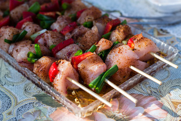 Close up pf delicious chicken breast on wooden skew with fresh vegetables, garlic, paprika fried on mangal barbeque grill