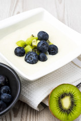 Semolina pudding with kiwi fruit and blueberries, sweet healthy and vegetarian meal concept.