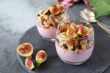 Two glasses of fruit yogurt with granola, figs and honey