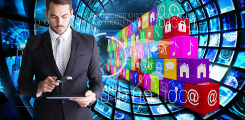 Concentrated businessman using magnifying glass against composite image of app wall