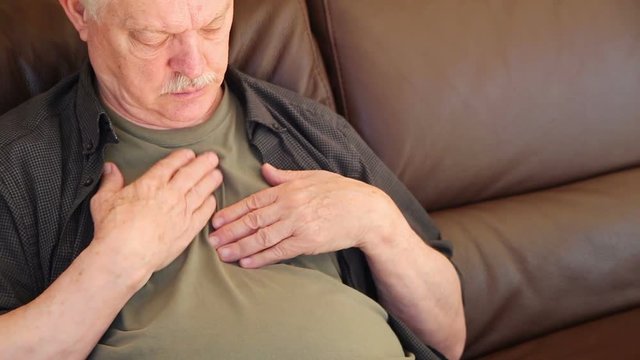 Seated older man experiences pain and pressure in his chest with room for text