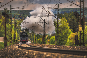 Steam locomotive at full throttle in the countryside