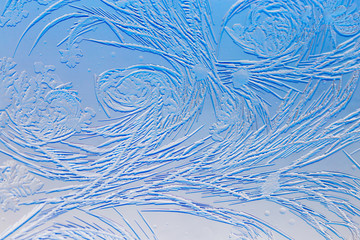 Blue drawings on the glass in the frost