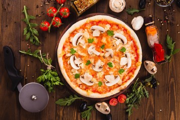 italian pizza with chicken and mushrooms on the wooden dark background (close top view).