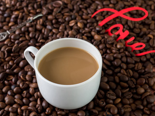 Cup of coffee with milk on background of coffee beans