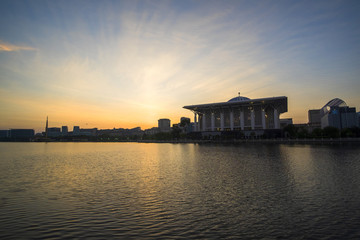 Scenery of Sunrise at Sultan Mizan Mosque,Putrajaya with clear blue sky and reflection. soft focus,blur due to long exposure. visible noise due to high ISO.