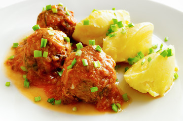 beef meatballs cooked with rice stewed in tomato sauce garnished with potato