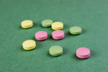 Pills and tablets on a green background