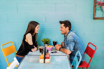 Happy young couple seating in a restaurant