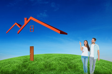 Happy casual couple walking together against green hill under blue sky