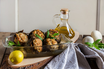 Baked artichokes stuffed with mushrooms and meat on a wooden background