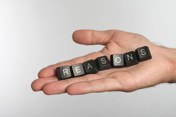 Open palm with seven computer buttons with word REASONS