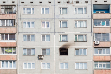 Fototapeta na wymiar The window burned apartment in a high-rise building.