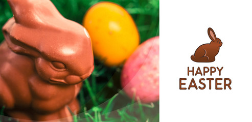 Happy Easter greeting against chocolate bunny with easter eggs