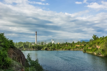 soft focus industrial factory pollution concept on natural quarry landscape with lake