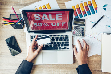 Business woman holding credit card and using laptop computer. Online shopping concept, Workplace strategy Concept.