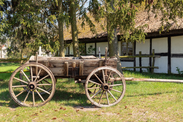 Fototapeta na wymiar Wooden cart near old house 
