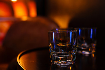 Glasses of whiskey on bar background