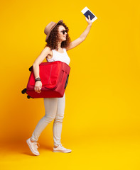 Woman traveler with suitcase on color background.