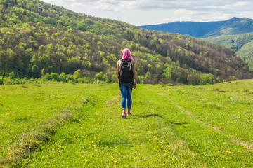Fototapeta premium soft focus backpack beautiful informal girl with pink hair in nature forest mountain landscape 
