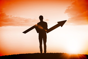 businessman with arrow against sun shining