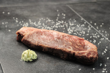 Raw pork meat on a dark gray