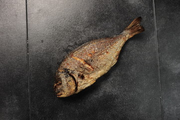 baked fish on a dark background