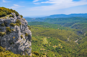 Fototapeta na wymiar Panoramablick vom Steilhang von den Alpen Frankreichs unter blauem Himmel, Toskana, Felsen mit sehr steiler Klippe im Vordergrund