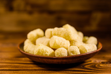 Ceramic plate with corn sticks on wooden table