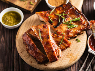 Delicious barbecued ribs seasoned with a spicy basting sauce and served with chopped fresh...