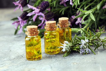 lavender oil in a glass bottle on a background of fresh flowers.