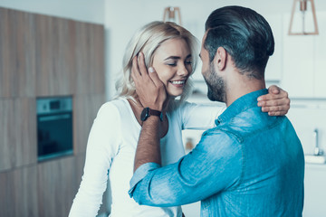 Loving happy couple together in kitchen.