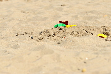 Fototapeta na wymiar Children's toys on the sea sand near the sea for entertainment and recreation for children.