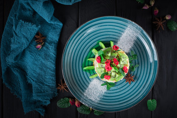 Delicious cake with fruit and mint decoration on black background