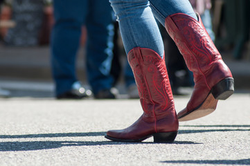 closeup of woman legs with red american boots at country show in outdoor - 203129419