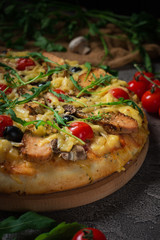 Pizza with chicken, arugula, cheese and onions on wooden rustic table. Top view