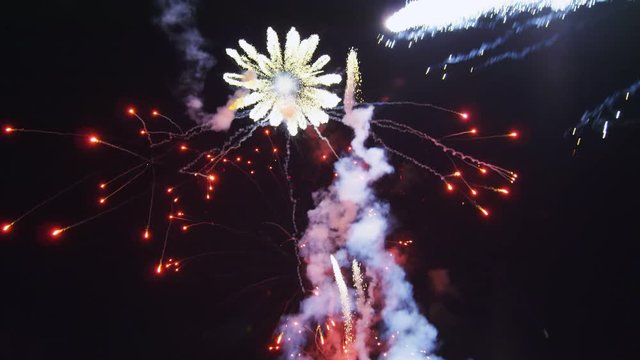 A fireworks display of bursting rockets trailing smoke