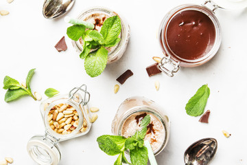 Chocolate-mint milkshake with pine nuts, gray background, top view