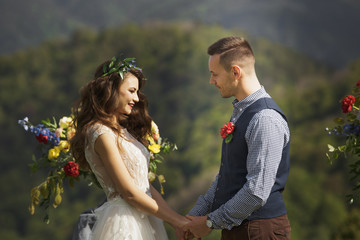 the bride and groom on the background of a mountain stream