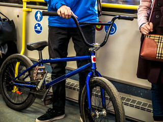 man stanidng in the public transport bus with the bicycle