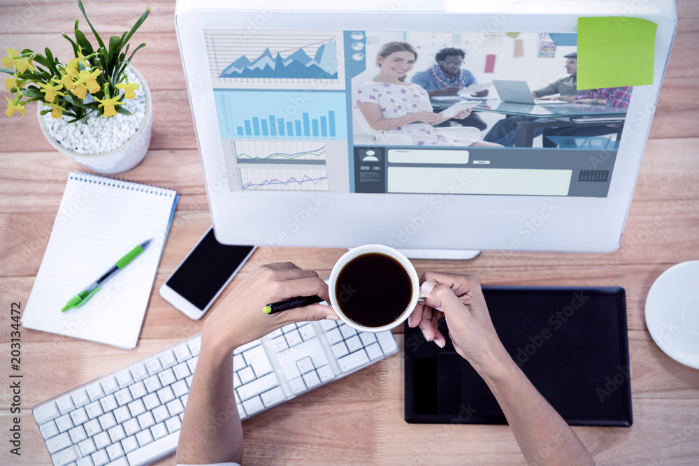 Poster editor holding tablet and smiling as team works behind her against part of hand using stylus