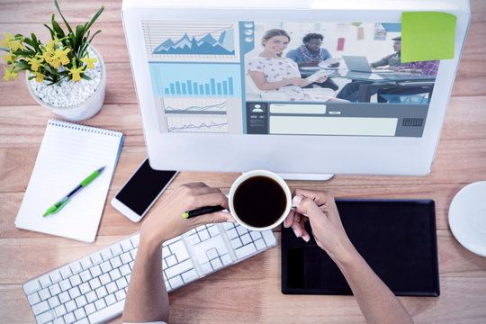 Editor holding tablet and smiling as team works behind her against part of hand using stylus