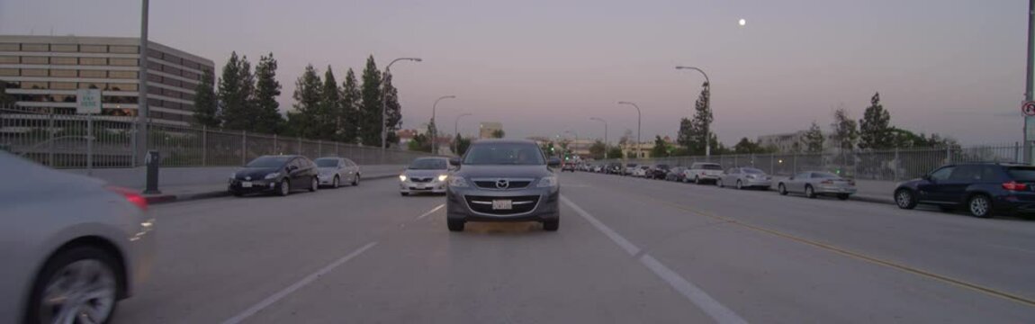 Rear view of a Driving Plate: Car travels on West Colorado Boulevard in Pasadena, California at dusk from St John Avenue to San Rafael Avenue.