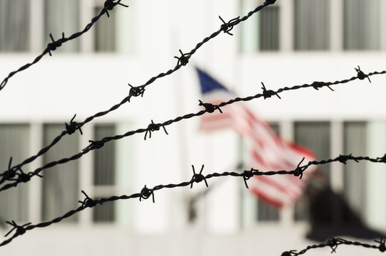 Barbed wire in the foreground and the blurred American flag in the background. Manhattan, New York city, USA.