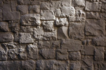 Fototapeta premium A stone wall with a sunbeam. Texture of wild stone.