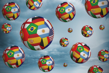 Footballs in international flags against desert landscape