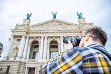 Obraz premium tourist man taking picture of old european architecture. copy space. travel concept