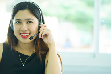 close up focus on asian call centre woman with headphone trying to response answer or working in operation office room.helpdesk hotline concept.